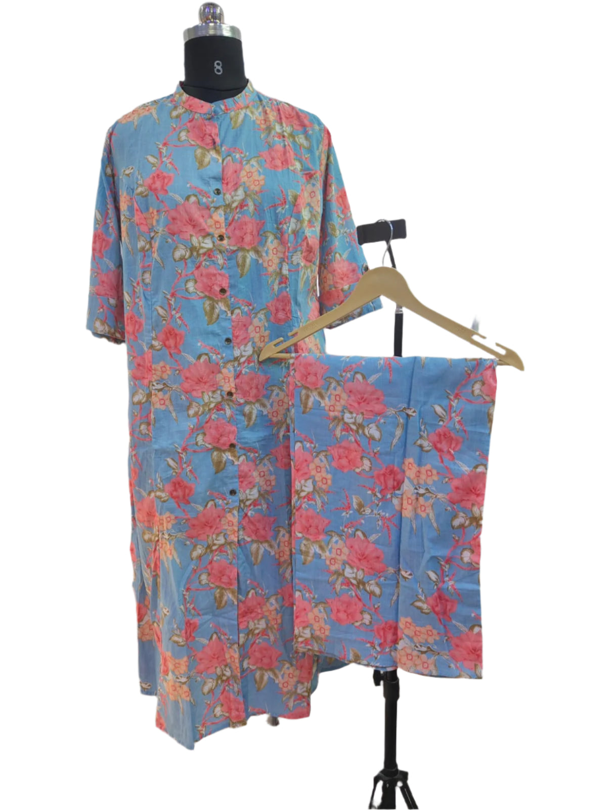Floral dress set on a mannequin and hanger against a white curtain background