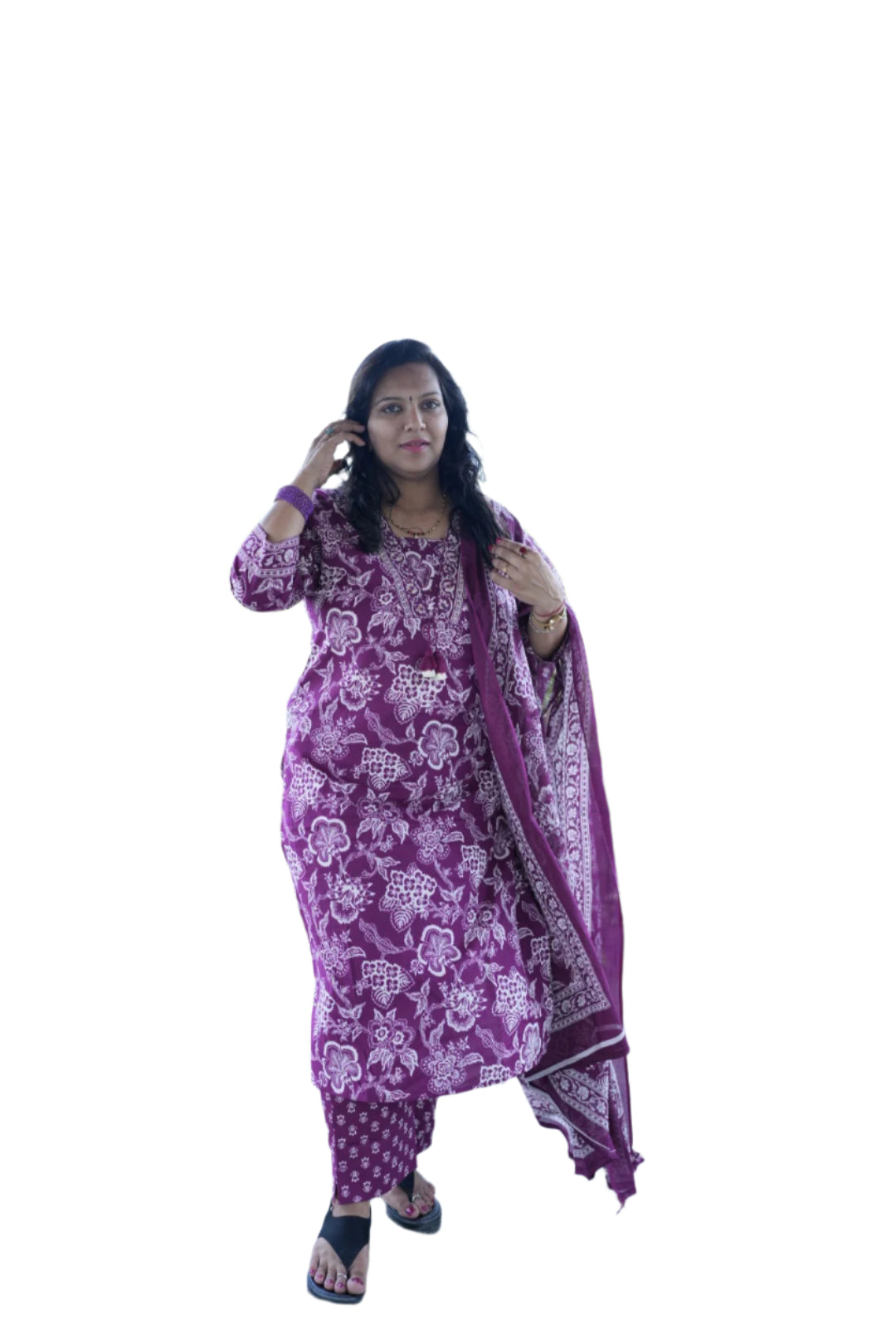 Woman in a pink traditional outfit standing outdoors with greenery in the background