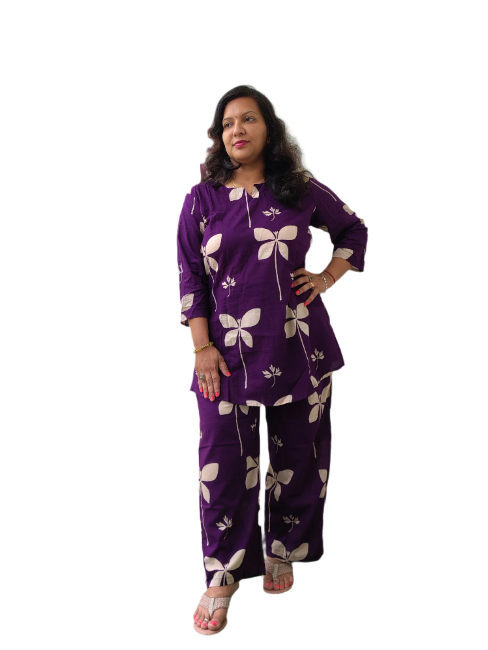 Person wearing a purple floral outfit standing indoors with a green carpeted floor.